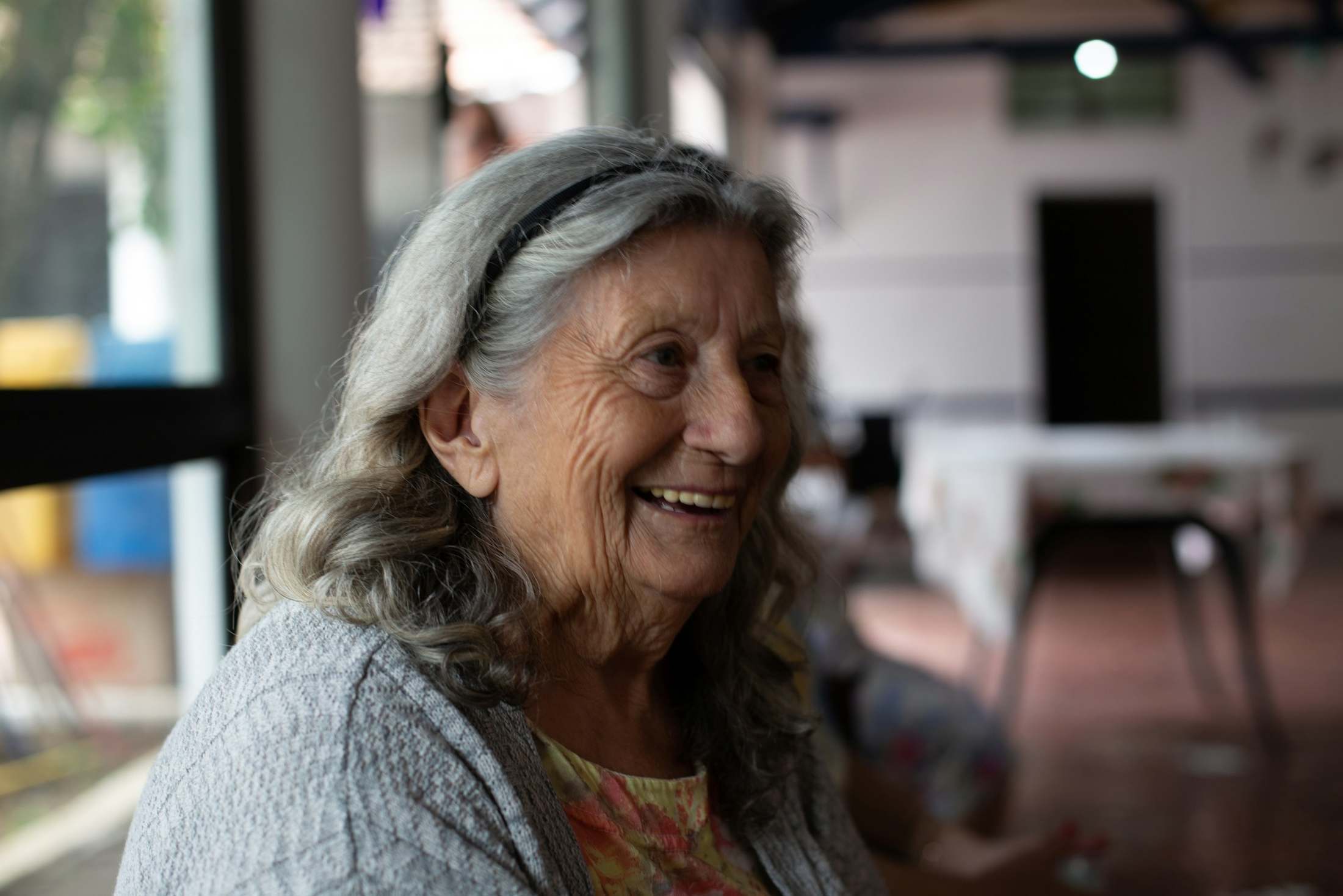 An older woman smiles warmly.